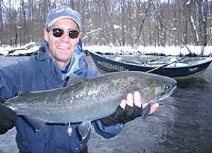 Salmon River fishing guides Pulaski NY drift boat. Landing a Steelhead off the Salmon River guides drift boat.